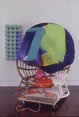 1995 Wicker chair, plastic tub, light fixture with bulb, synthetic polymer, oil paint, plastic, fabric, concrete, resin, wood, wheels, acrylic yarn, glass and cookie in resin 71.5 x 63 x 50 in 181.6 x 160 x 127 cm Collection Whitney Museum of American Art, New York: gift of the Jack E. Chachkes Estate, by exchange, and purchase with funds from the Peter Norton Family Foundation and Linda and Ronald F. Daitz